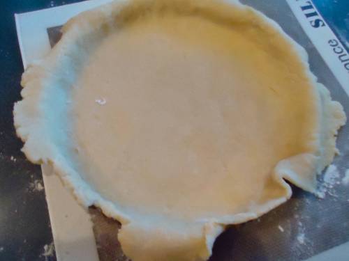 Line the tart pan with the pastry, trim the edges and prick the bottom and side a with a fork. This will keep the pastry flat while it bakes. You can also use pastry beans/beads but the fork method works great for me.