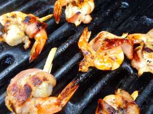 shrimp wrapped in bacon and skewered with sugar cane