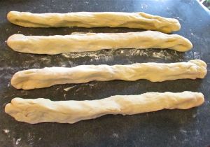 Punch the dough down, separate into 4 evenly sized balls and then roll out into 4 evenly sized strands.